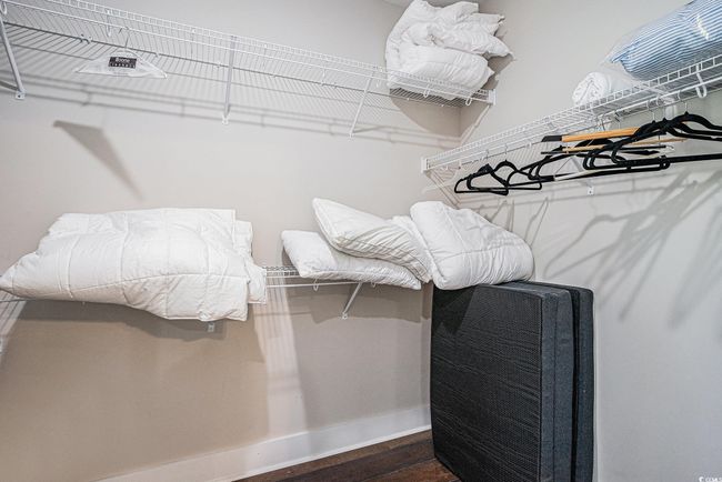 Walk in closet featuring dark wood-style flooring | Image 16