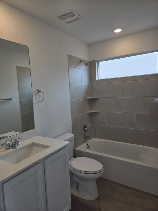Bathroom with wood finished floors, vanity, and bathtub / shower combination | Image 6