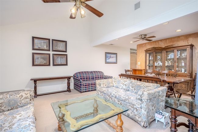 Dining room featuring ceiling fan, recessed lighting, wooden walls, and light colored carpet | Image 11