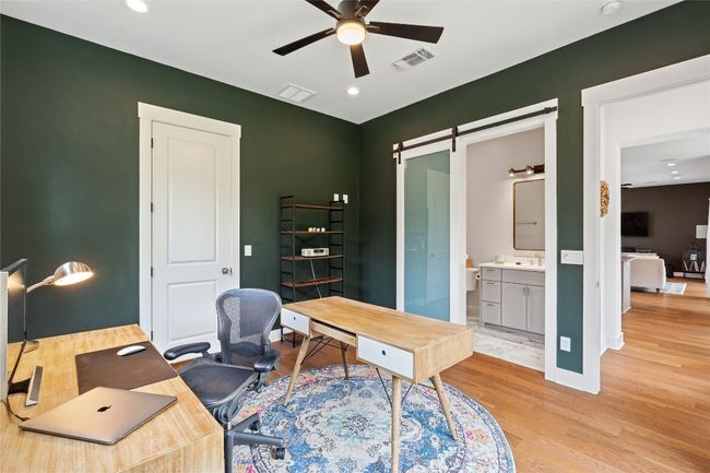 Office area featuring a ceiling fan, light wood-style flooring, a barn door, recessed lighting, and a sink | Image 21