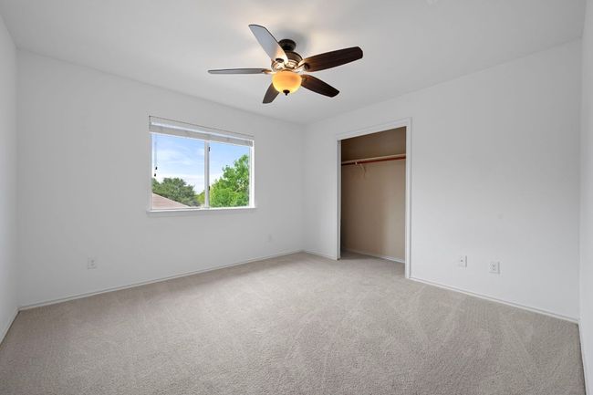 Unfurnished bedroom featuring light colored carpet, a closet, ceiling fan, and baseboards | Image 22
