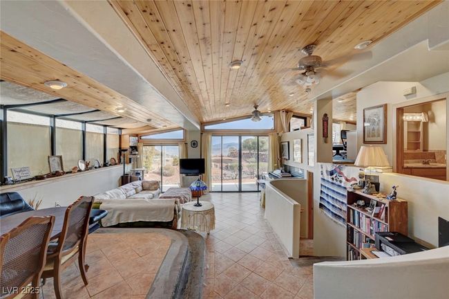 Bedroom featuring light tile patterned floors, lofted ceiling, wooden ceiling, and access to outside | Image 17