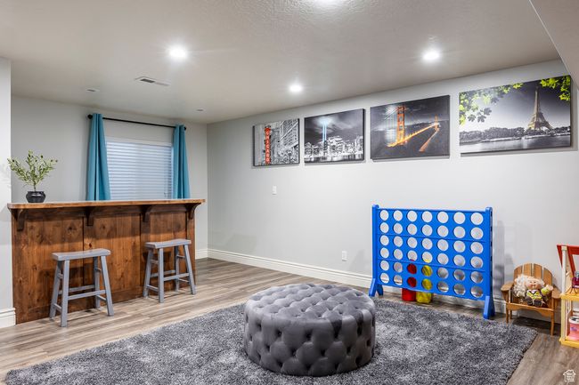 Rec room with hardwood / wood-style floors and bar area | Image 30