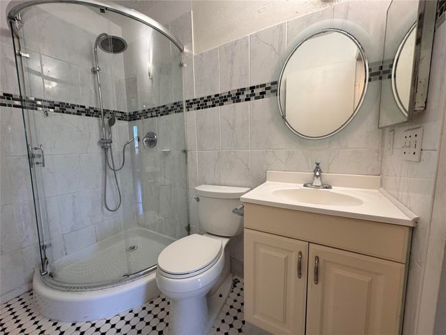 Bathroom featuring vanity, a stall shower, and tile walls | Image 11