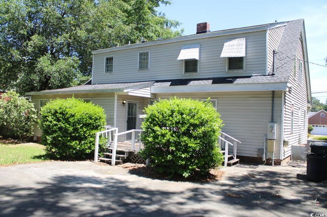 View of front of home featuring roof with shingles, a chimney, and a deck | Image 7