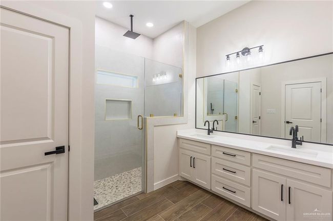 Bathroom with vanity and a shower with shower door | Image 4