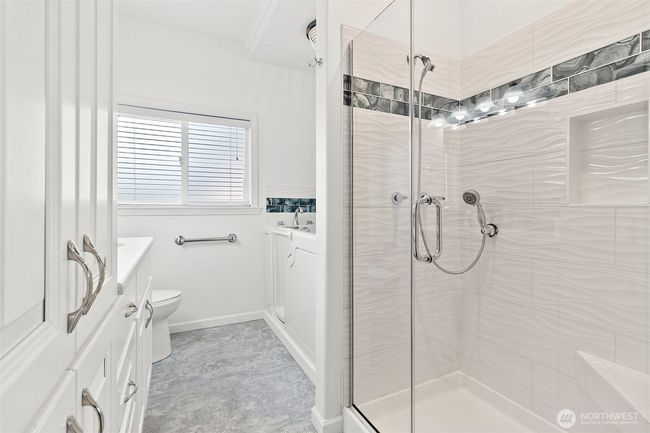 Primary full bathroom, featuring full height tile shower and walk-in tub. | Image 25