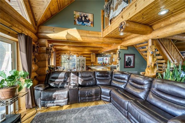 Living area with wood finished floors, high vaulted ceiling, beam ceiling, stairs, and wood ceiling | Image 9