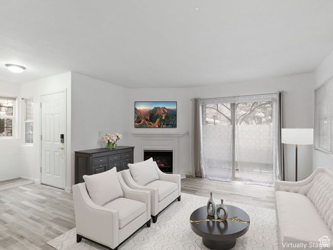 Living area with light wood-style floors and a lit fireplace | Image 4