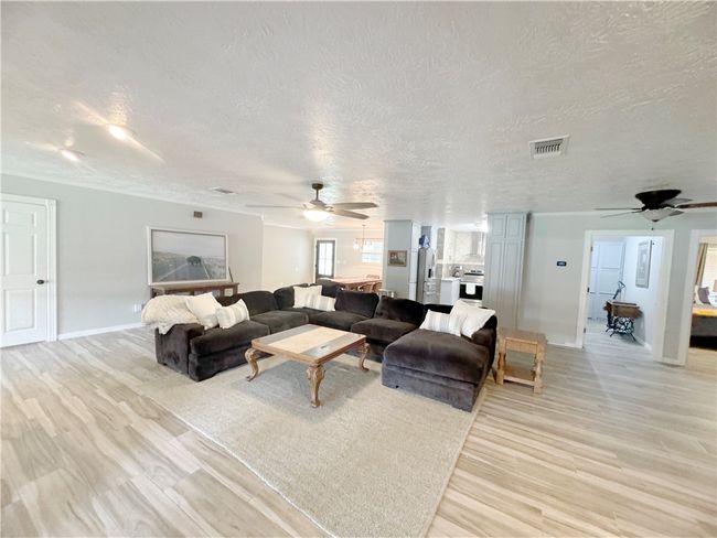 Living room featuring a textured ceiling, visible vents, baseboards, and ceiling fan | Image 13