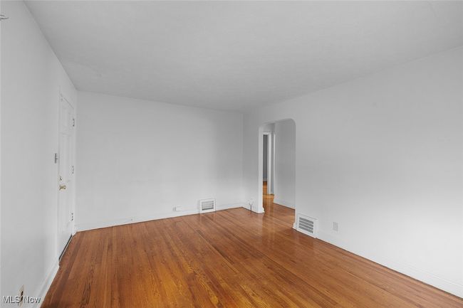 livingroom with wood finished floors, visible vents, baseboards, and arched walkways | Image 9