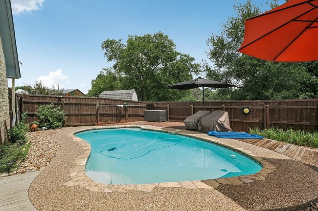 View of swimming pool with a fenced backyard | Image 27