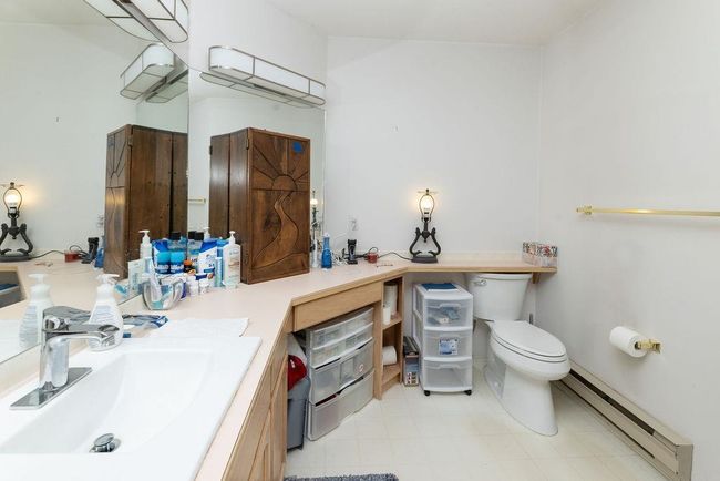 Bathroom with toilet, a baseboard radiator, and vanity | Image 23
