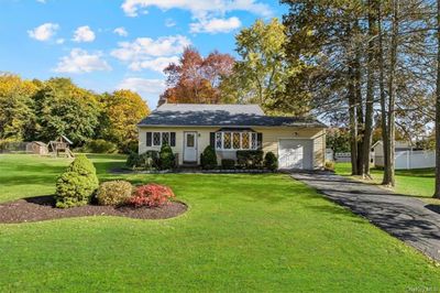 View of front of property featuring a front lawn, a playground, and a garage | Image 2