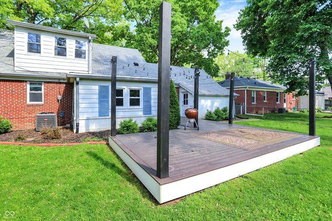 rear view of house with a deck, central air condition unit, and brick siding | Image 44