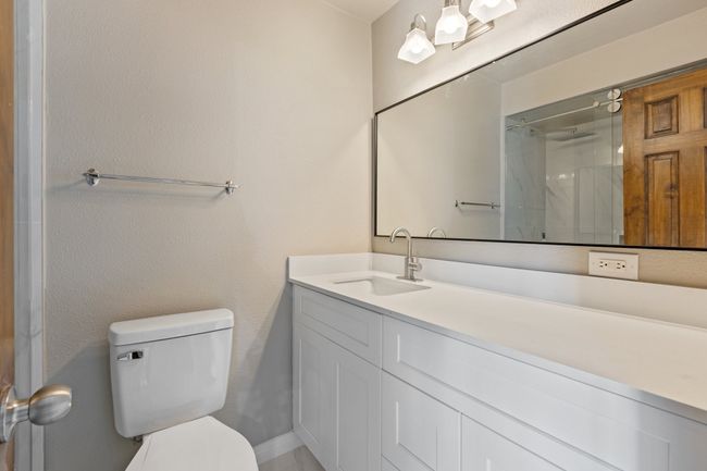 Full bathroom with toilet, a shower, and vanity | Image 16