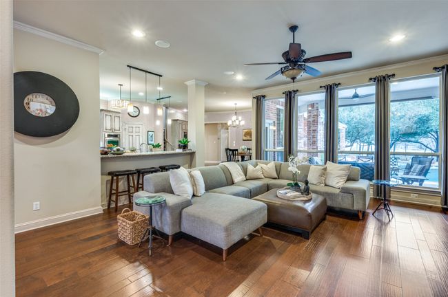 Living area featuring a chandelier, a ceiling fan, ornamental molding, dark wood-style flooring, and recessed lighting | Image 5