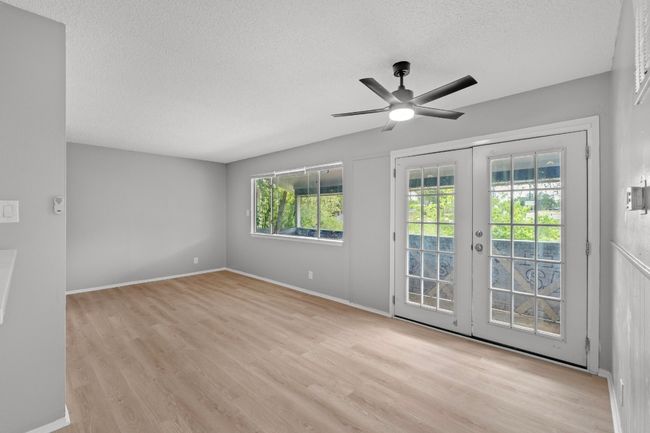 Spare room with wood finished floors, a textured ceiling, a ceiling fan, and french doors | Image 7