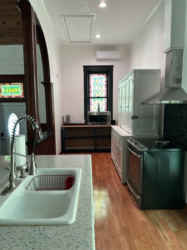 Kitchen with white range oven, light wood-style flooring, ornamental molding, extractor fan, and recessed lighting | Image 4