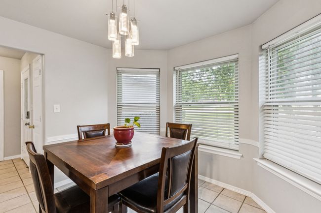 Dining area featuring light tile patterned flooring and baseboards | Image 8
