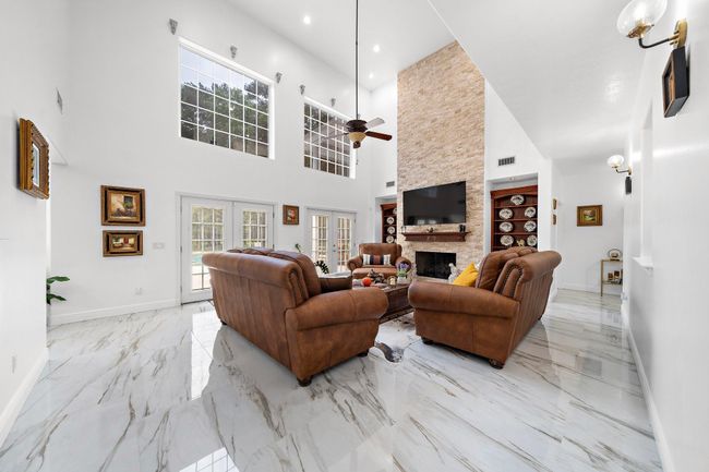 Spacious living area with large windows and natural light | Image 4