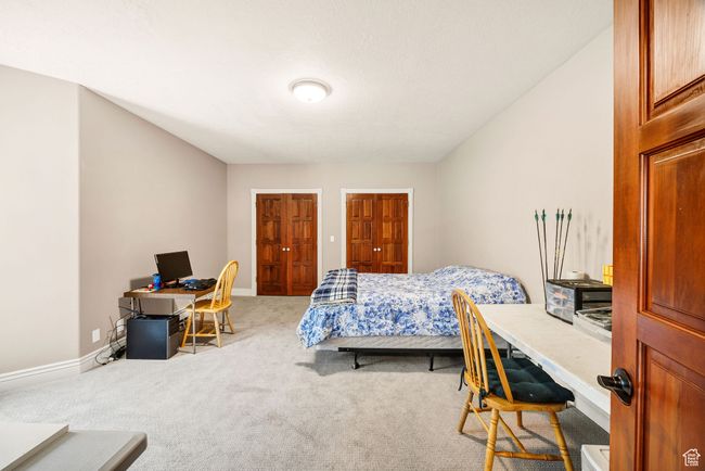 Bedroom with a desk, carpet flooring, and multiple closets | Image 66