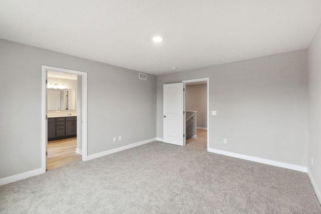 Primary bedroom with walk-in closet and private bath. Model home. Options and colors will vary. | Image 22
