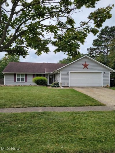 View of front of home with a garage and a front lawn | Image 1