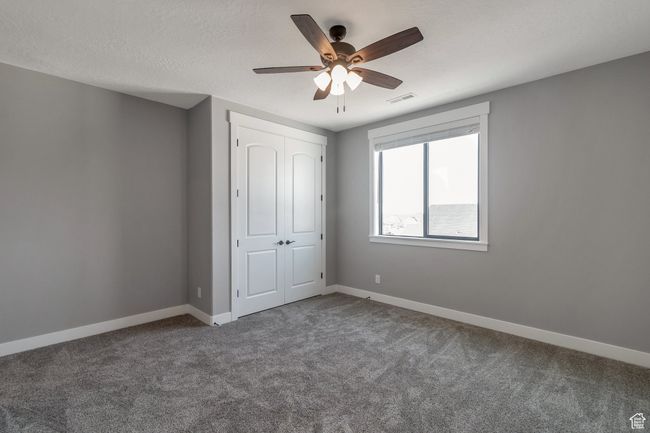 Unfurnished bedroom with carpet, a closet, and ceiling fan | Image 24