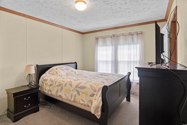 Carpeted bedroom featuring ornamental molding and a textured ceiling | Image 36
