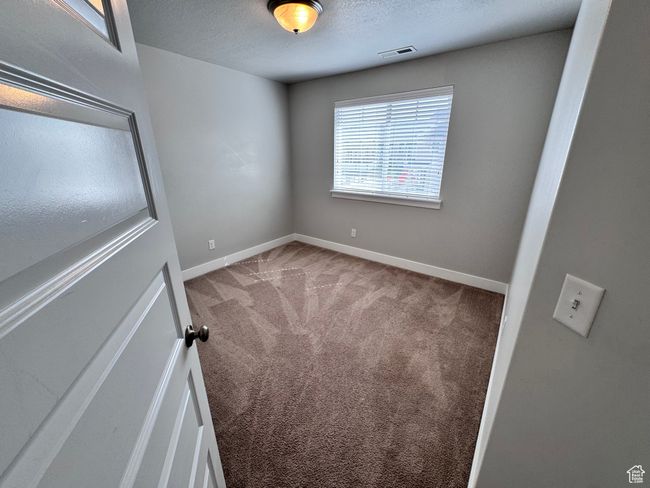 Spare room with a textured ceiling, visible vents, carpet, and baseboards | Image 25