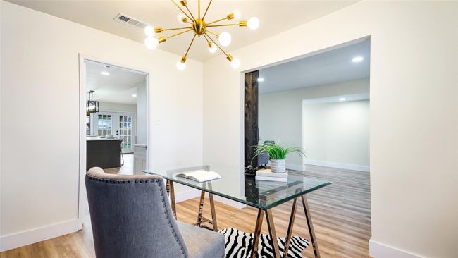 Office area featuring an inviting chandelier, light wood-style flooring, visible vents, french doors, and baseboards | Image 19