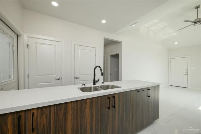 Kitchen with a sink, light marble finish flooring, light countertops, a ceiling fan, and recessed lighting | Image 10