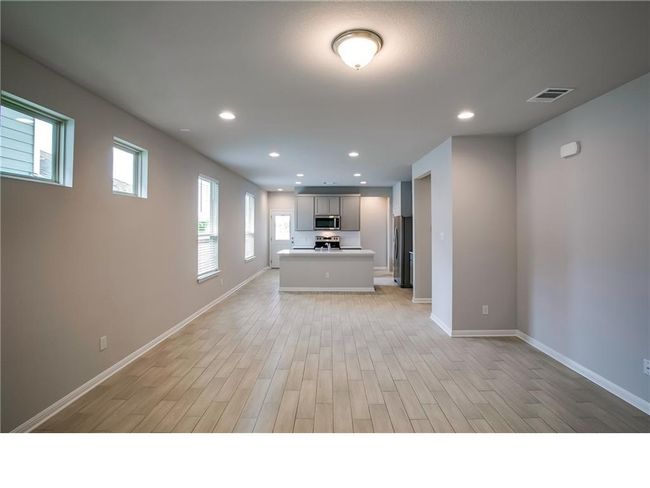 Kitchen featuring stainless steel appliances, open floor plan, light wood-style flooring, light countertops, and recessed lighting | Image 5
