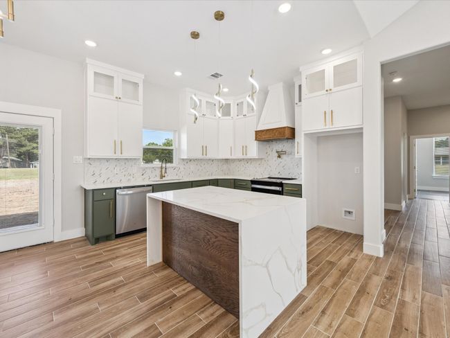 Kitchen featuring dishwasher, premium range hood, light wood finished floors, healthy amount of natural light, and recessed lighting | Image 9
