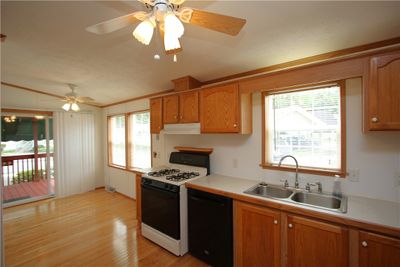 HUGE 22x10 Eat-in Kitchen w/ Beautiful Hardwood Floors, Breakfast Nook upon Entry from Sliding Glass Door off of Covered Deck, Plenty of Wood Cabinetry, 2 Ceiling Fan Lights, Double Bowl Stainless Steel Sink & All Appliances Included! | Image 3