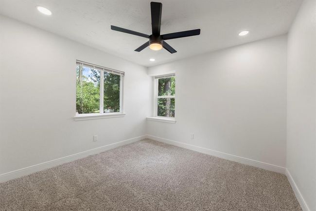 Additional bedroom (3) located upstairs features plush carpet, nice natural light, ceiling fan, and canned lights. | Image 22