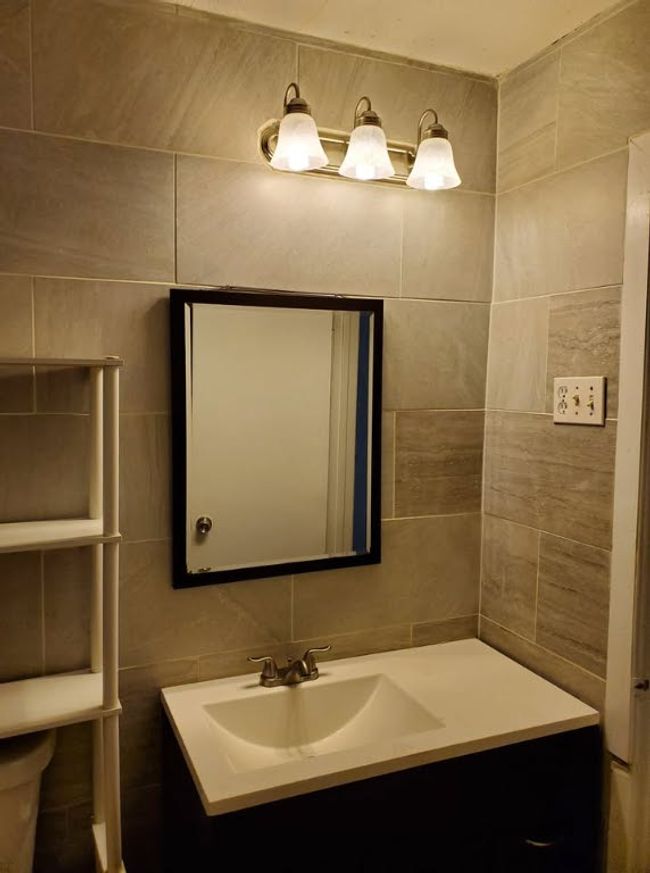 Bathroom with tile walls, vanity, and decorative backsplash | Image 19