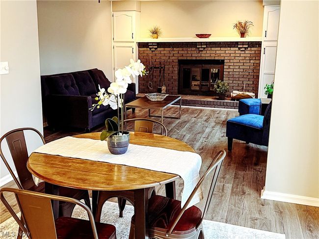 Dining room with a brick fireplace and light hardwood / wood-style floors | Image 10