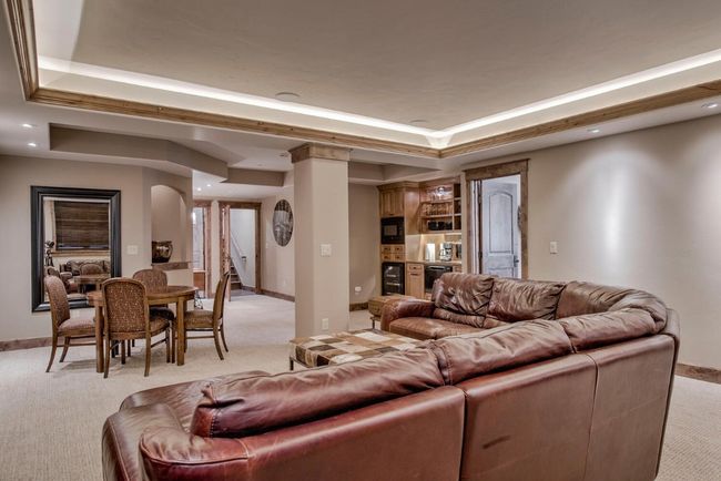 Head to the lower level to check out another warm and cozy gathering space. Built-in wet bar and space for games! | Image 33