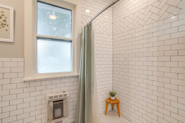 Bathroom with heating unit, a tile shower, and tile walls | Image 35