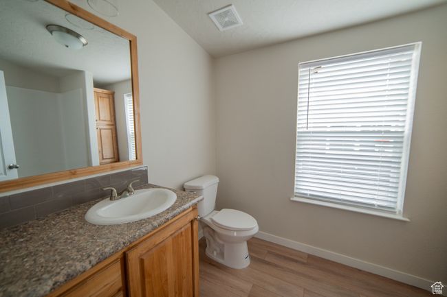 Bathroom with plenty of natural light, baseboards, visible vents, decorative backsplash, and wood finished floors | Image 33