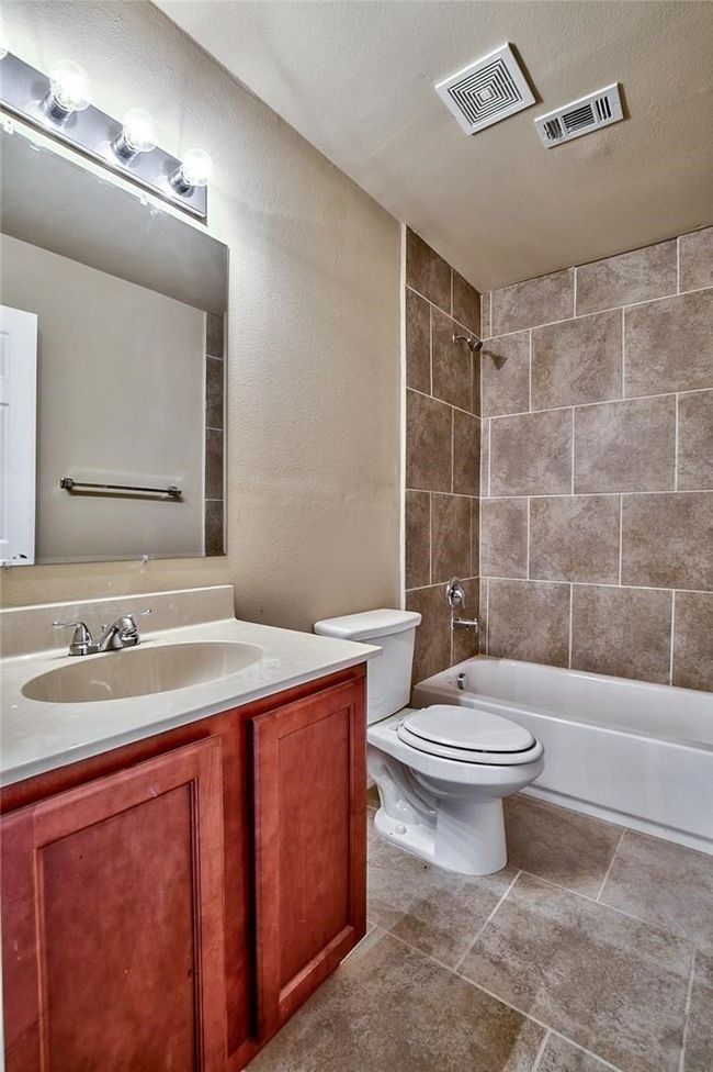 Full bathroom featuring vanity, washtub / shower combination, and tile patterned flooring | Image 14