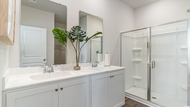 Full bath with double vanity, a stall shower, and wood finished floors | Image 17