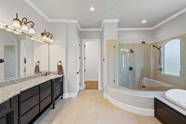 Bathroom with vanity, ornamental molding, tile patterned flooring, a bath, and a tile shower | Image 22