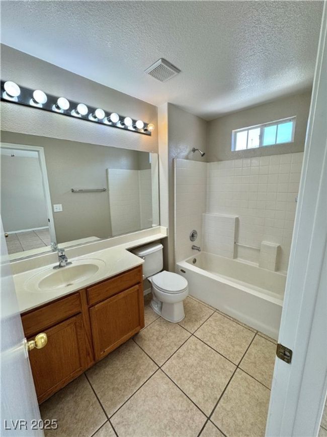 Full bath with bathing tub / shower combination, visible vents, toilet, vanity, and a textured ceiling | Image 15