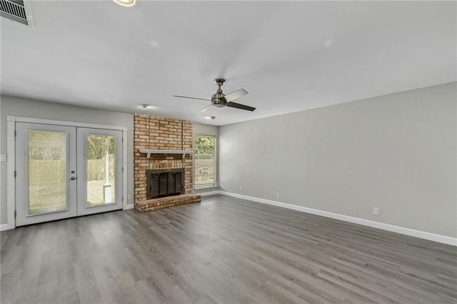 Unfurnished living room featuring wood finished floors and baseboards | Image 5