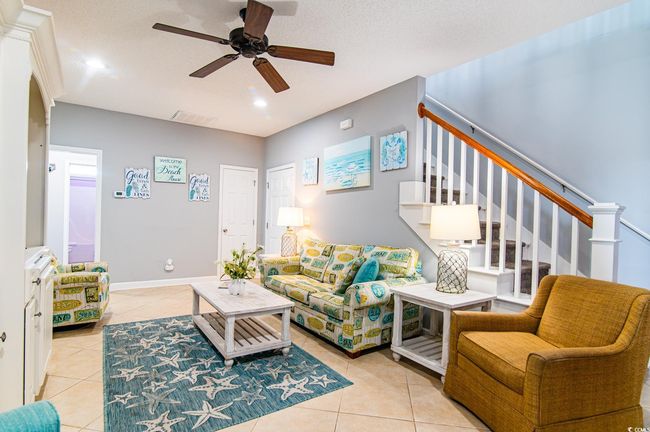 Living area featuring ceiling fan, tile patterned flooring, stairs, and recessed lighting | Image 13