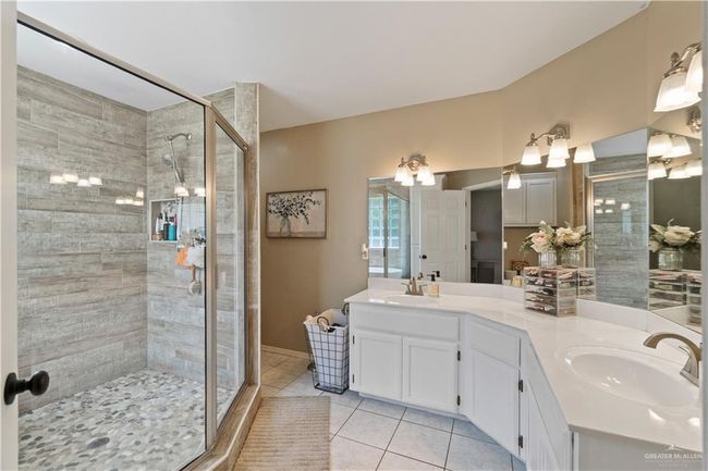 Bathroom featuring tile patterned flooring, a stall shower, and double vanity | Image 19