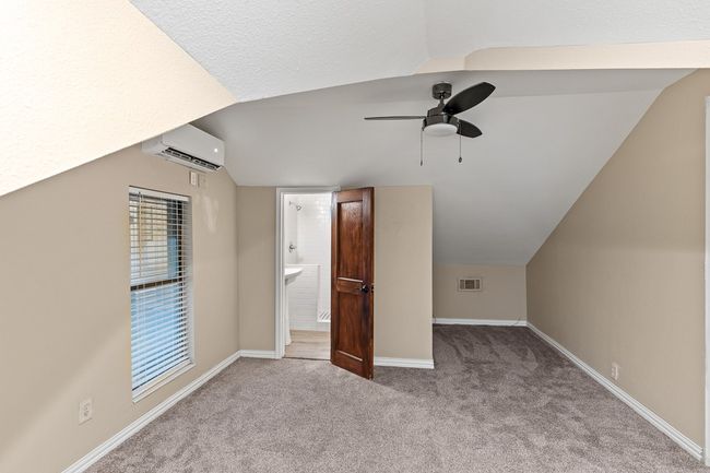 Bonus room featuring vaulted ceiling, ceiling fan, carpet flooring, an AC wall unit, and baseboards | Image 29